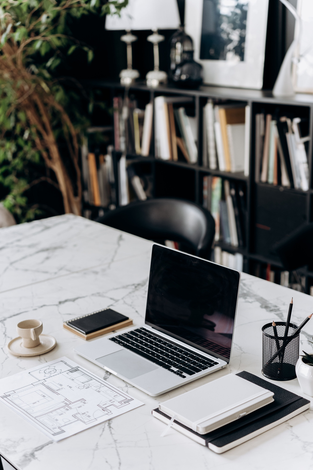 Laptop, notebook and architectural plans on a desk